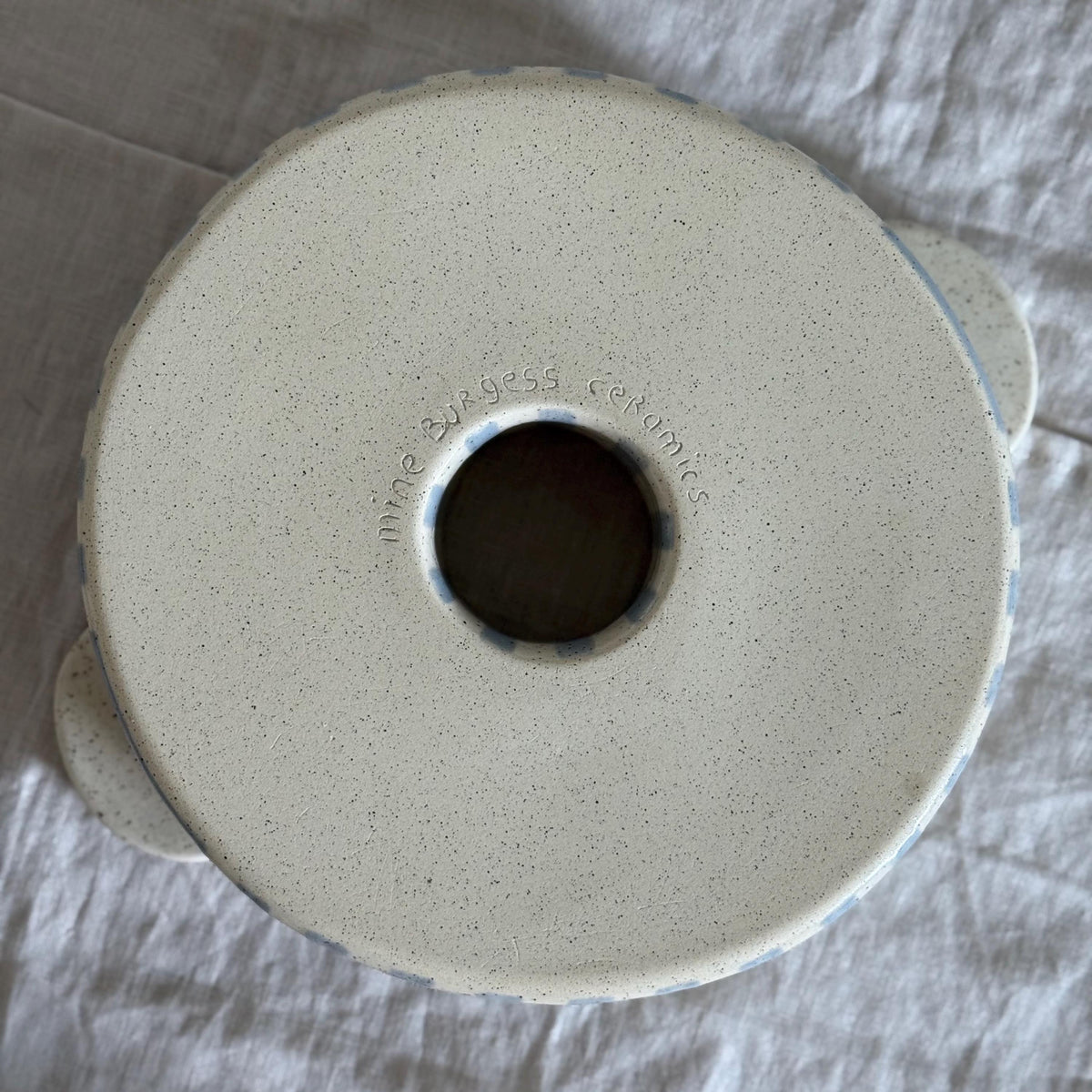Underside of the ceramic bundt pan with its central opening and maker's mark.