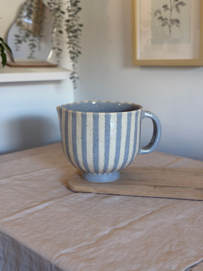 Blue and cream striped ceramic mixing bowl with a handle, pouring spout and raised foot.