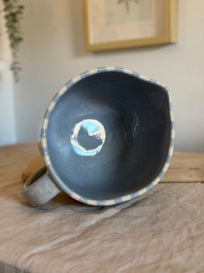Overhead view into the striped mixing bowl's blue-gray glazed interior.