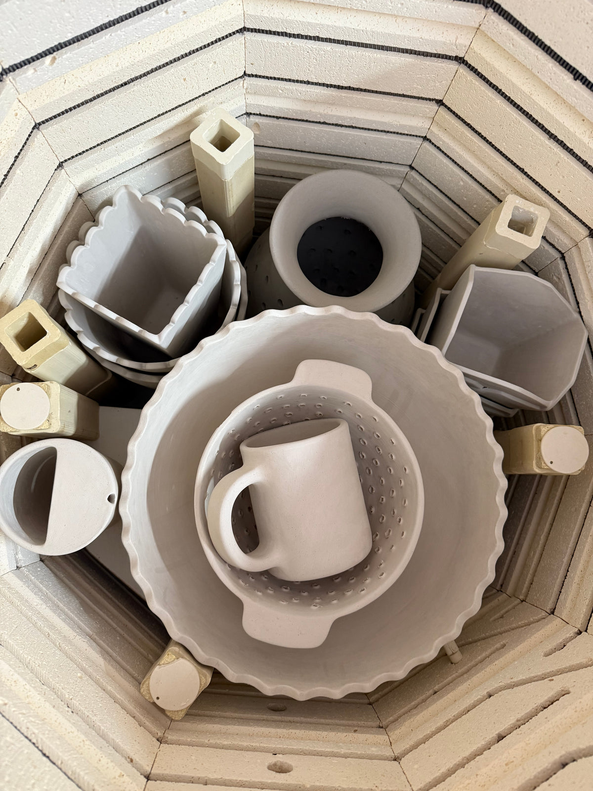 Mugs and dishes arranged inside the kiln