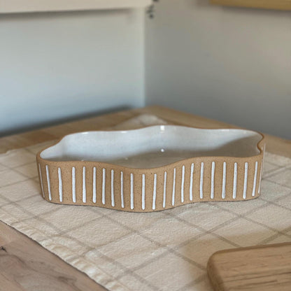 Side view of the long Striora dish's flowing outline and striped walls.