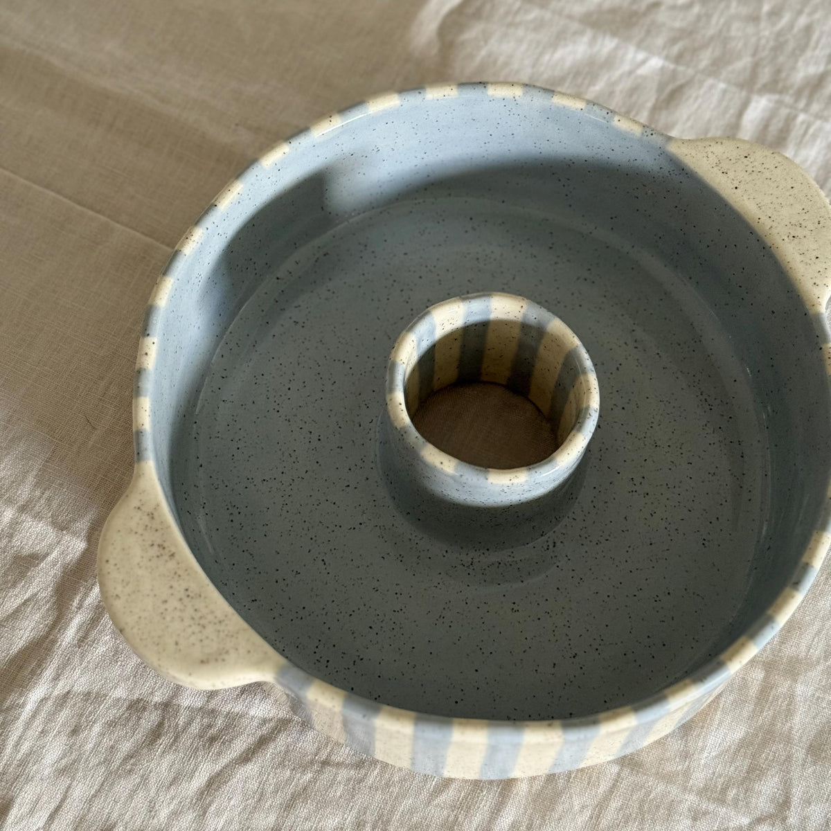 Elevated view into the blue-gray bundt pan with stripes inside the center tube.
