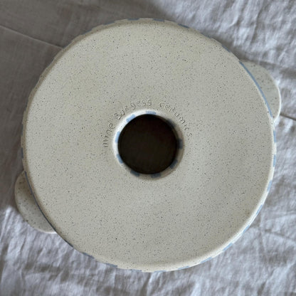 Underside of the ceramic bundt pan with its central opening and maker's mark.