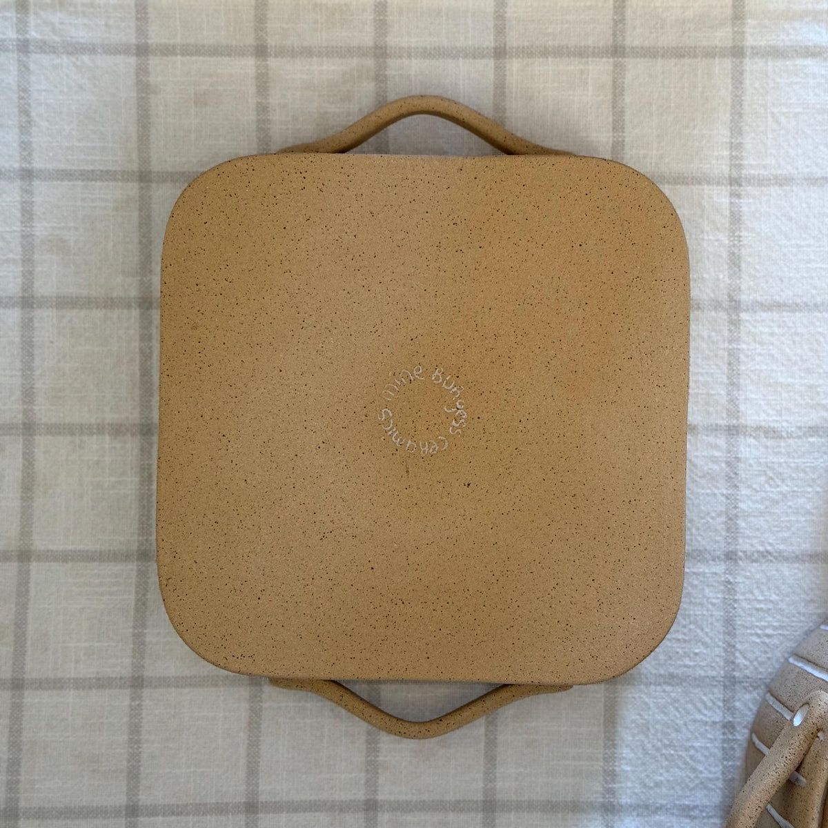 Underside of the square Striora dish, showing its unglazed base and maker's stamp.