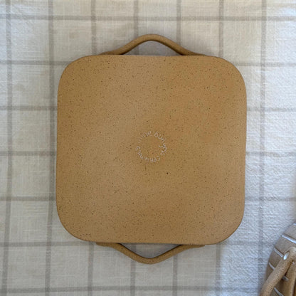 Underside of the square Striora dish, showing its unglazed base and maker's stamp.