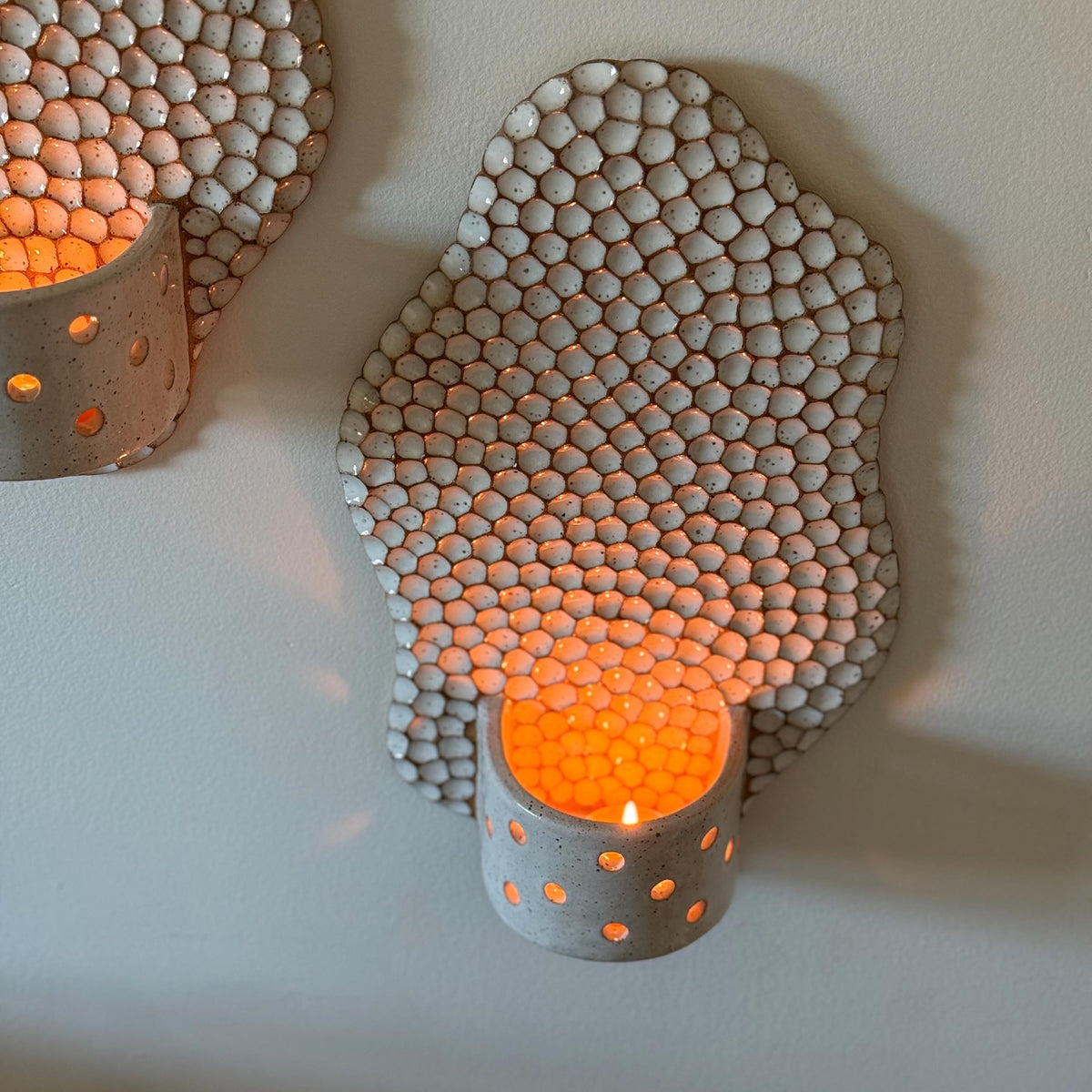 Elevated view into the lit honeycomb holder's perforated cup.
