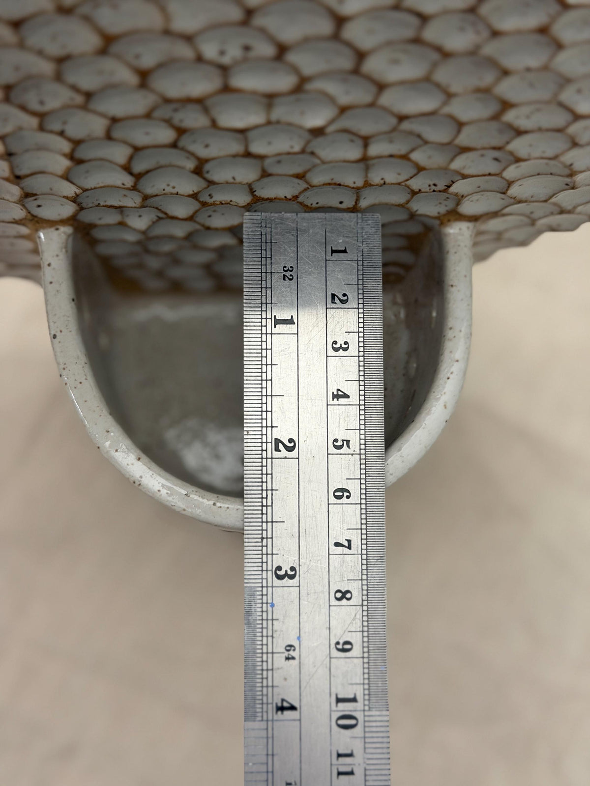 Ruler measuring the depth of the honeycomb wall holder's candle cup.