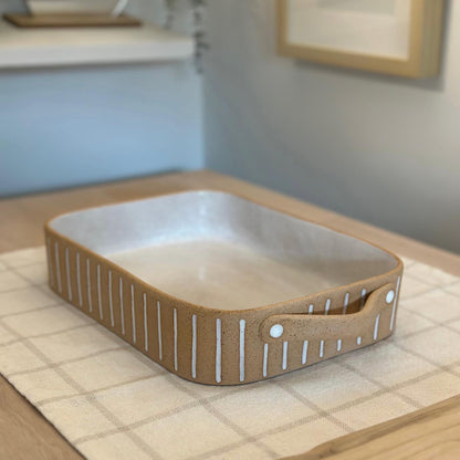 Closer angled view of the rectangular dish's rounded corners and striped sides.