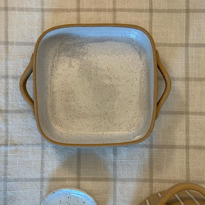 Closer overhead view of the square Striora dish's speckled glazed interior.