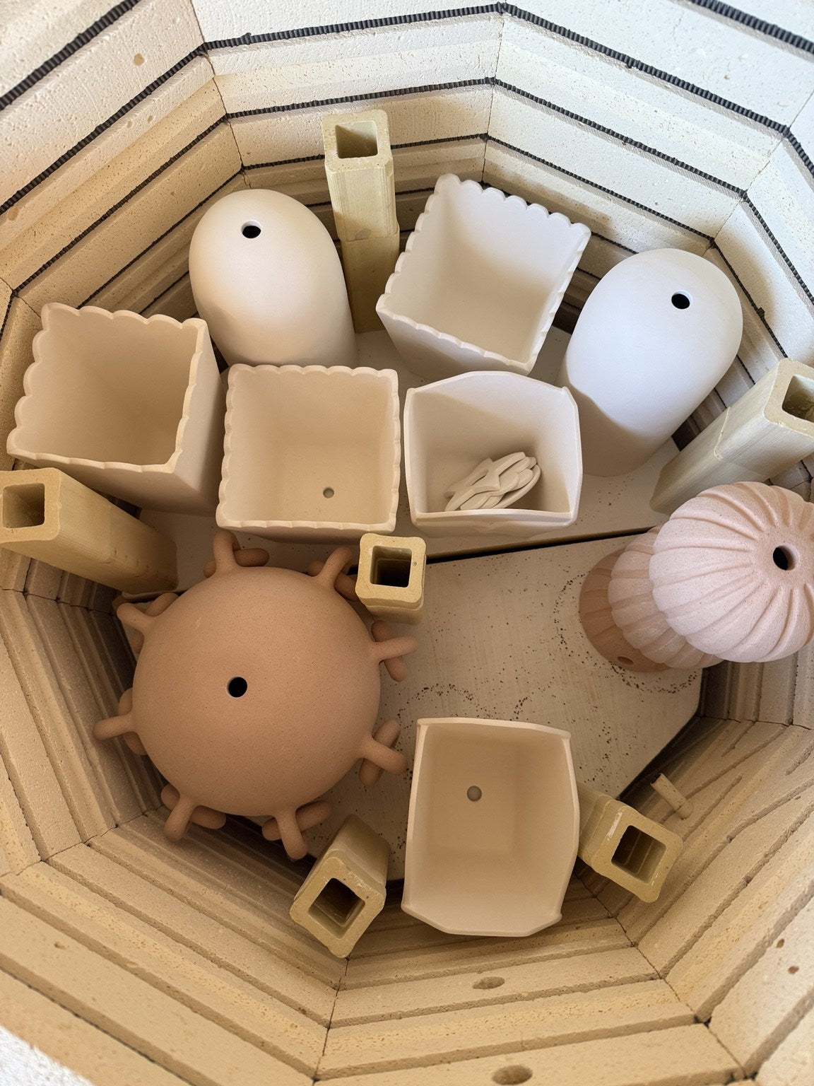 Unfinished ceramic lighting forms inside the kiln